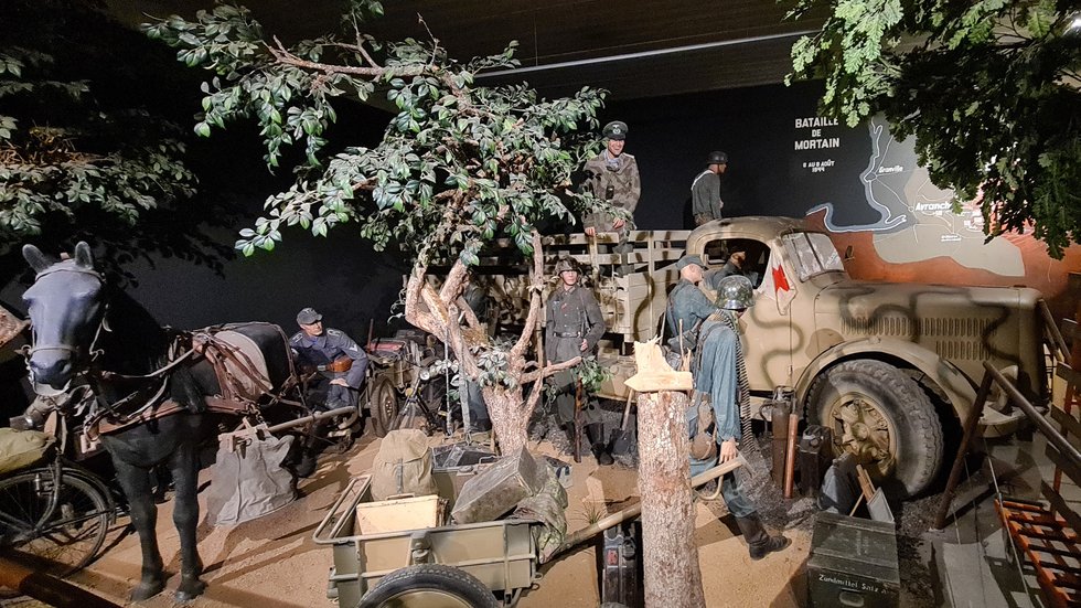 Lifelike diorama at the Normandy Victory Museum featuring German soldiers, a military truck, and a horse-drawn cart