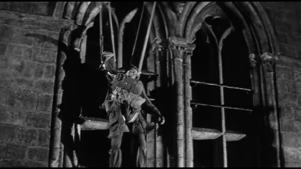 Screenshot from The Longest Day (1962) — Red Buttons as John Steele hanging from the church steeple